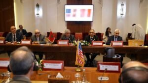 Séance de table ronde officielle avec des officiels marocains et des représentants du Comité juif américain, drapeaux visibles