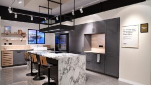 Showroom Aviva con isla de mármol, gabinetes grises y diseño moderno