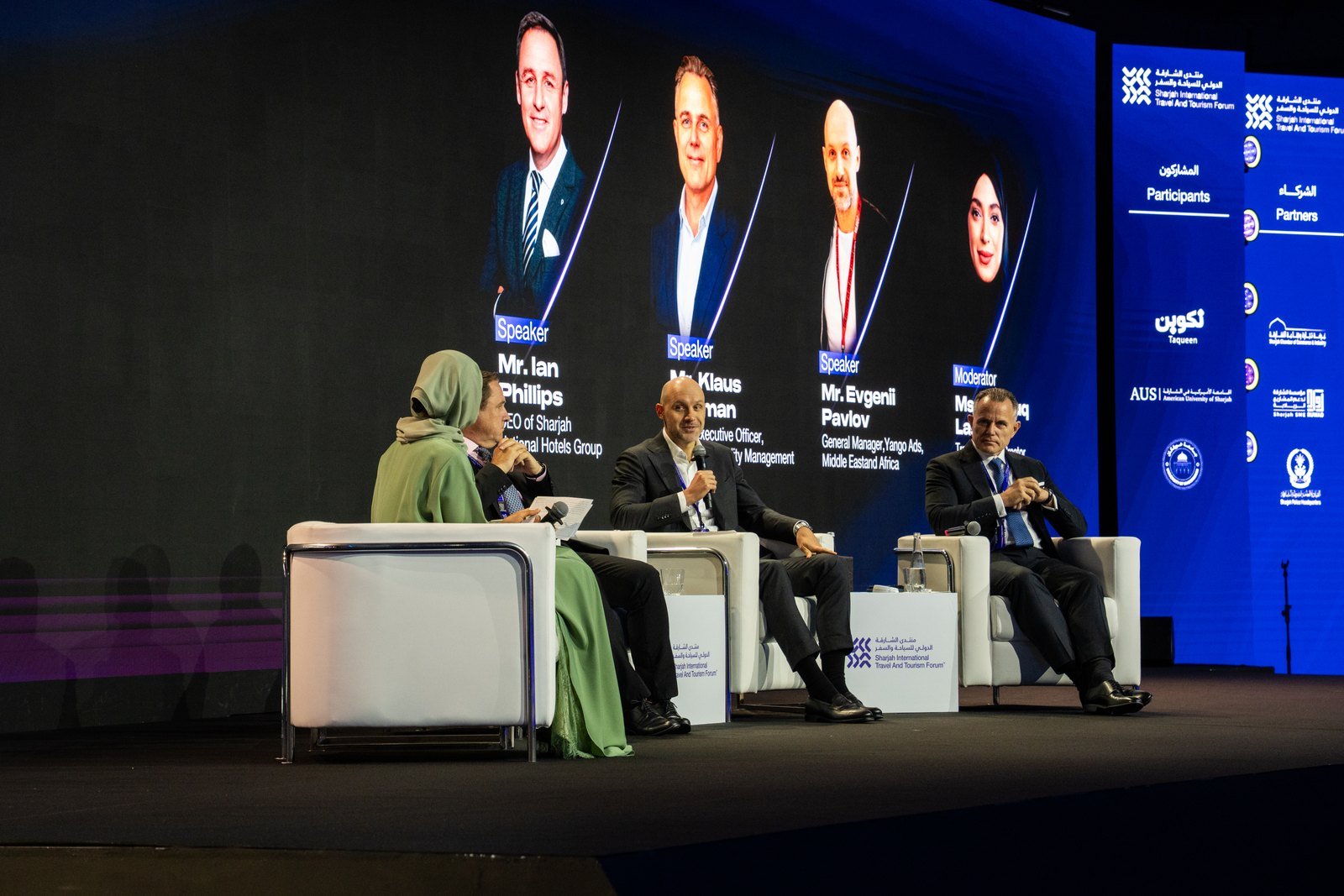 Panel discussion onstage featuring tourism and hospitality sector speakers at forum