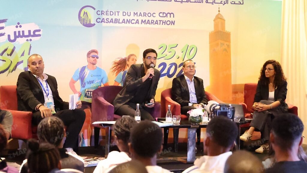 Cinq panélistes assis sur scène lors d'une conférence de presse du Marathon de Casablanca