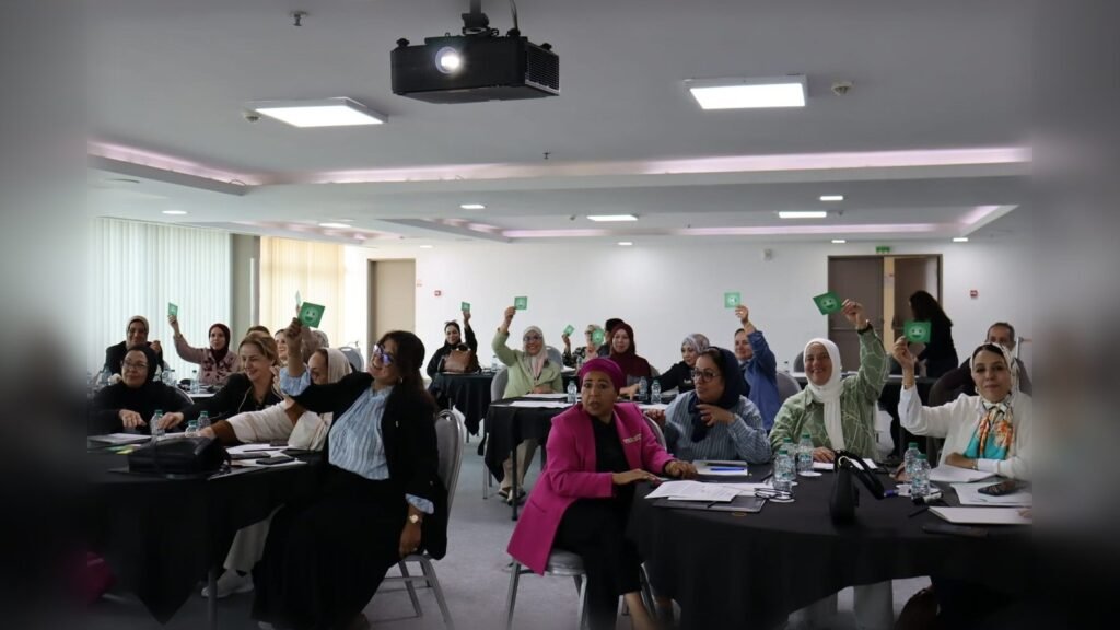 Participantes levantando la mano durante un taller de capacitación en emprendimiento