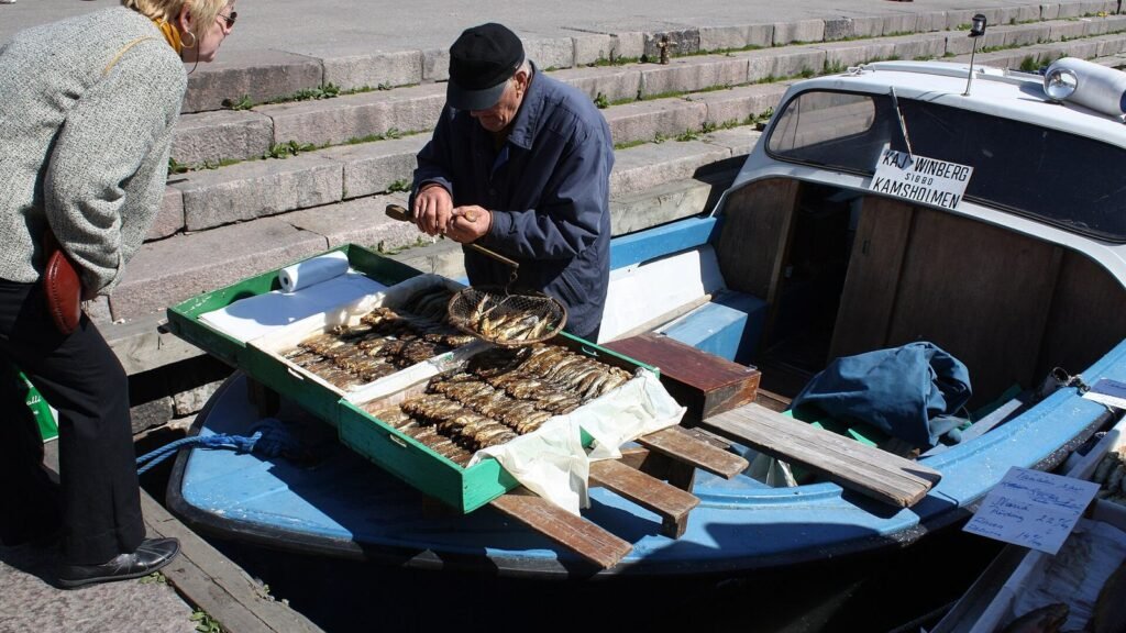 Fishmonger displaying smoked herring at a market stall