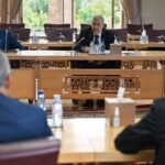 Official meeting session with multiple political party representatives and leaders seated