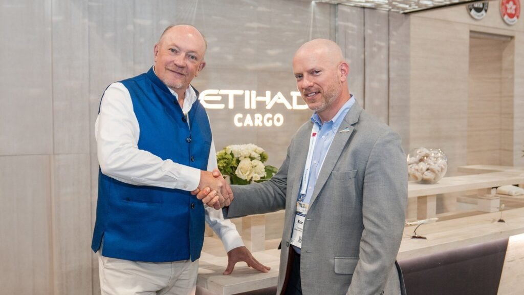 Business handshake at Etihad Cargo office with white flowers visible in background