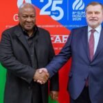 Two dignitaries shake hands at the official summit event