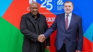 Two dignitaries shake hands at the official summit event
