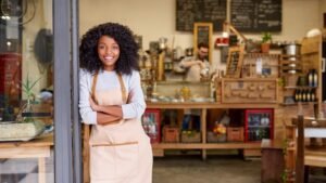 Woman entrepreneur with arms crossed standing in her craft workshop