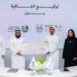 Quatre personnes tenant un gros chèque lors de la signature d'un accord de collaboration