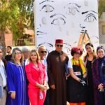 Groupe d'officiels et d'invités devant une installation artistique au festival Rues Art