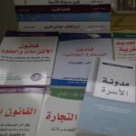 Stacked Moroccan law books with Arabic text on covers