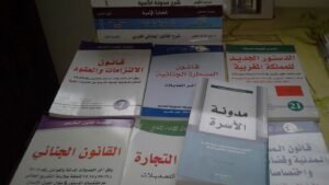 Stacked Moroccan law books with Arabic text on covers