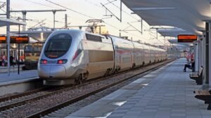 Silver and red Al Boraq train stopped at railway station platform