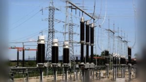 High-voltage electrical station with transformers and metal towers under clear sky