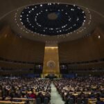 Vista general de la sala de la Asamblea General de la ONU con delegados y emblema de la organización
