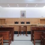 Interior of empty Moroccan courtroom with traditional wooden furnishings