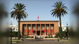 واجهة برلمان المغرب بعمارة حمراء وبرتقالية مع نخيل