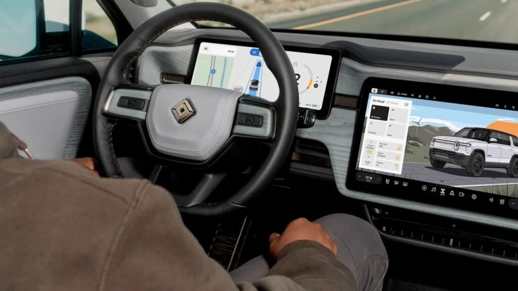سائق في سيارة Rivian مع شاشات عرض تكنولوجيا القيادة الذاتية والملاحة