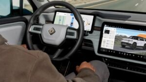 سائق في سيارة Rivian مع شاشات عرض تكنولوجيا القيادة الذاتية والملاحة