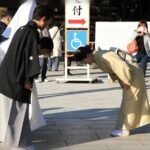 امرأة يابانية في ملابس تقليدية تنحني بعمق أمام شخص آخر