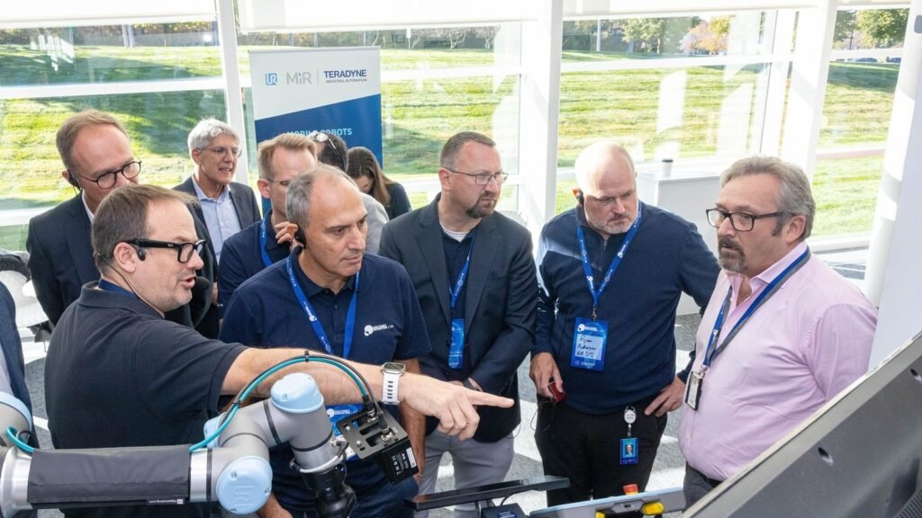 Group of badge-wearing men observing an industrial device during a demonstration